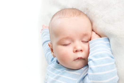 little boy sleeping on soft white blanket
