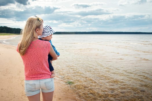 young woman and baby at the beach near sea