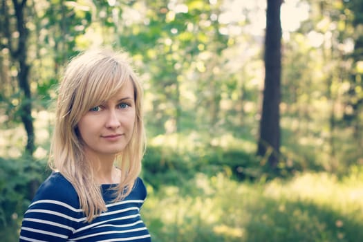 young woman in the forest on sunny summer day