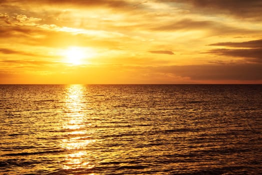 sunset at the sea with beautiful orange water and clouds