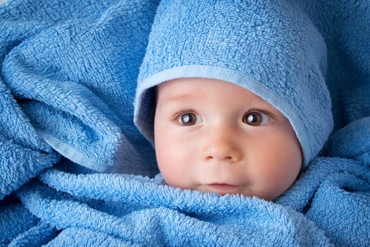 Cute eight month old baby wrapped in a towel