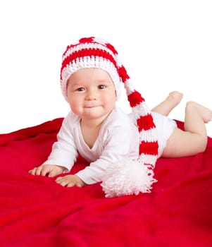 little baby in knitted red whitey hat on red blanket