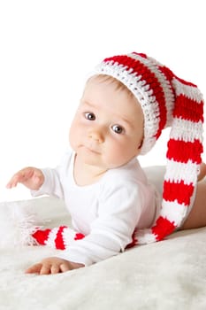 little baby in knitted red whitey hat on red blanket