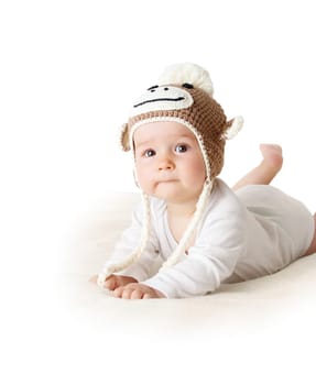 little baby in knitted monkey hat on brown blanket