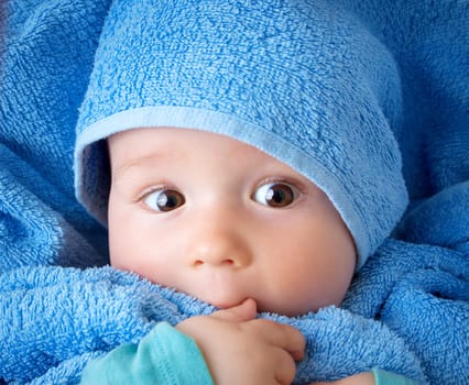 Cute eight month old baby wrapped in a towel