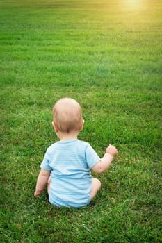 Little baby boy sitting on the grass