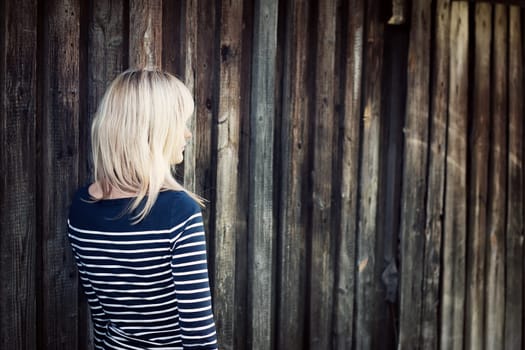 Young woman portrait infront of rustic wooden wall