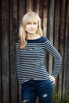 Young woman portrait infront of rustic wooden wall