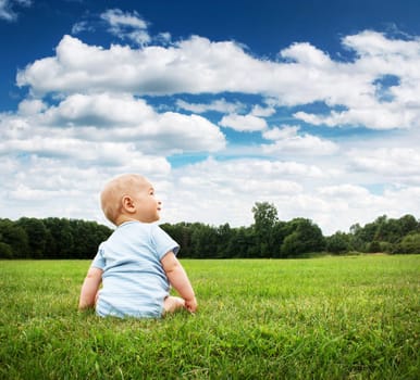 Little baby boy sitting on the grass