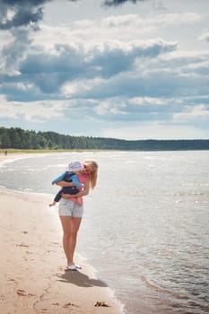 young woman and baby at the beach near sea