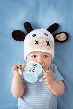cute baby in a cow hat drinking milk