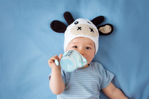 cute baby in a cow hat drinking milk