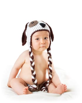 cute baby in dog hat sitting isolated on white background