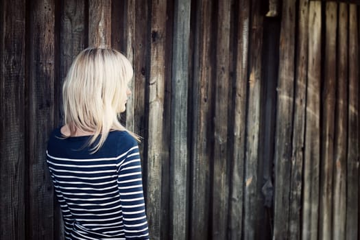 Young woman portrait infront of rustic wooden wall