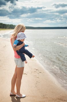 young woman and baby at the beach near sea