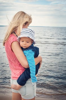 young woman and baby at the beach near sea