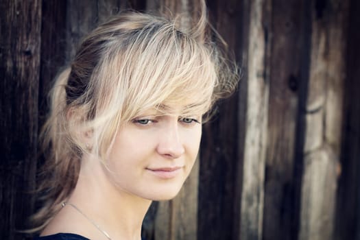 Young woman portrait infront of rustic wooden wall