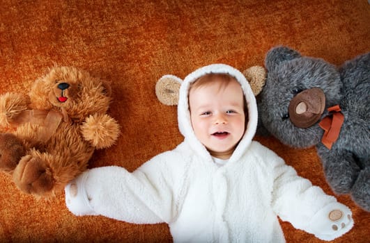 11 months baby in bear costume with plush toys