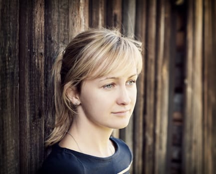 Young woman portrait infront of rustic wooden wall