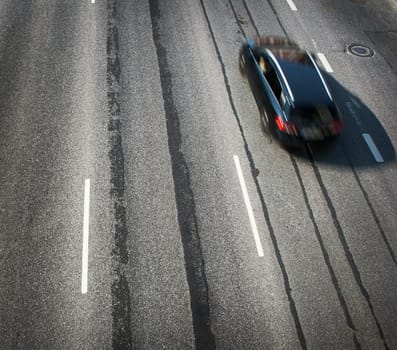 Black car moving on old highway road view from top
