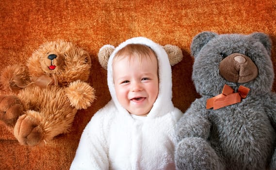 11 months baby in bear costume with plush toys
