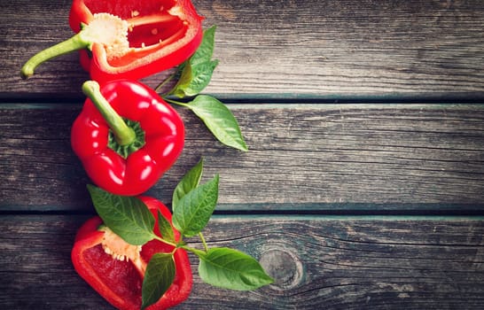 Fresh sweet red pepper on old wooden background