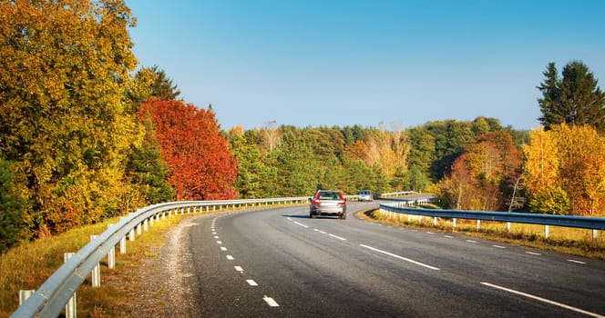 cars moving on a highway road in autumnal landscape