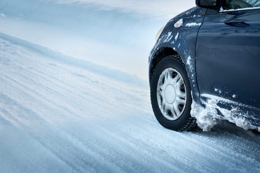 Closeup of car tires in winter on the road covered with snow