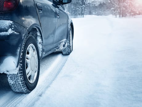 Closeup of car tires in winter on the road covered with snow