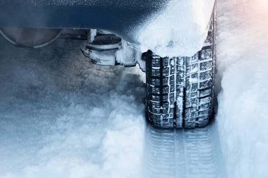 Closeup of car tires in winter on the road covered with snow