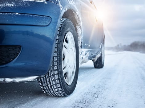Closeup of car tires in winter on the road covered with snow