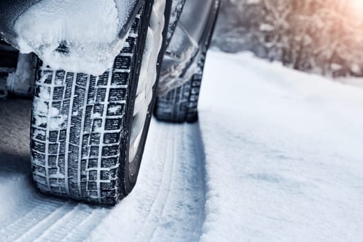 Closeup of car tires in winter on the road covered with snow