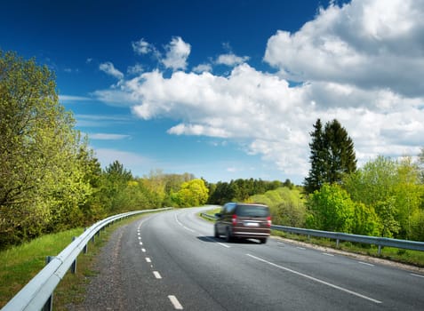 Car on asphalt road in beautiful spring day at countryside