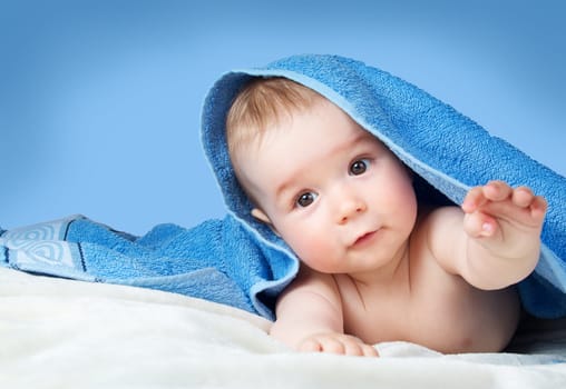 Cute eight month old baby wrapped in a towel