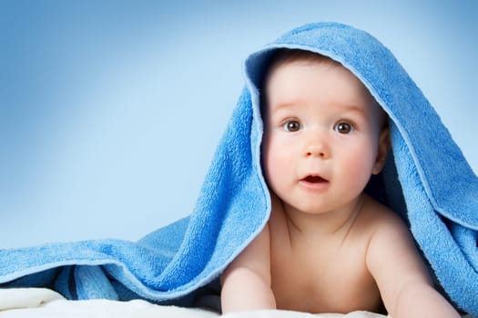 Cute eight month old baby wrapped in a towel