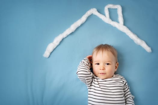 little boy lying on blue blanket with lots of question marks