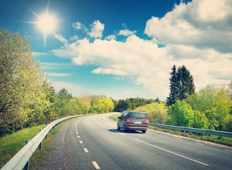 Car on asphalt road in beautiful spring day at countryside