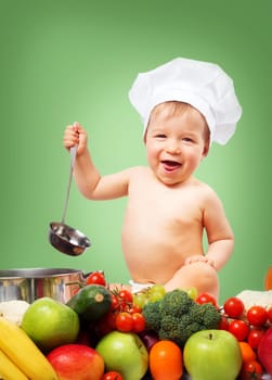 Baby boy in chef hat with cooking pan and raw vegetables