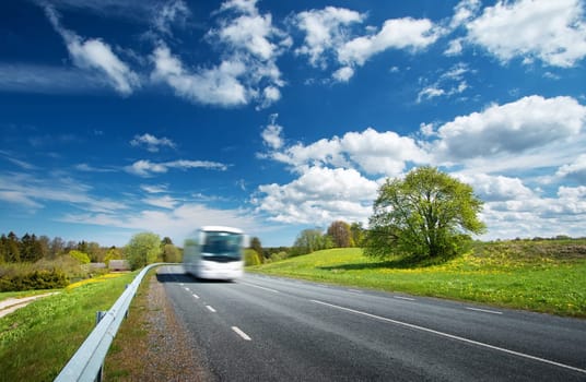 Bus on asphalt road in beautiful spring day at countryside