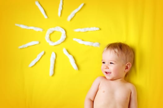 little one year old boy and sun shape on yellow blanket