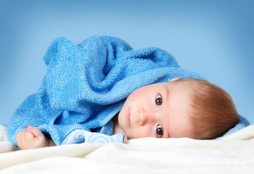 Cute eight month old baby wrapped in a towel. Baby hygiene. Adorable little boy
