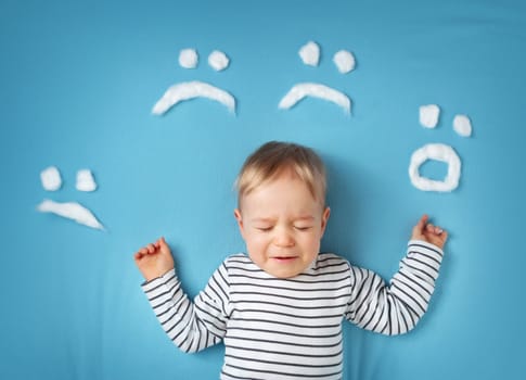 happy little boy on blue blanket background with smiley faces