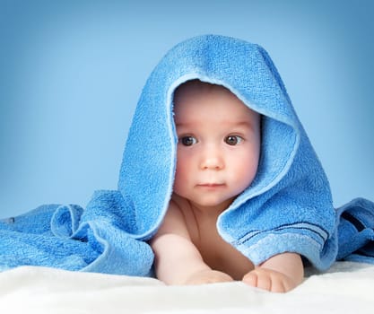 Cute eight month old baby wrapped in a towel