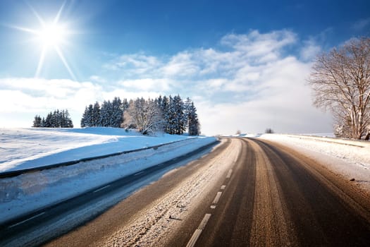 Asphalt road in snowy winter on beautiful frosty sunny day