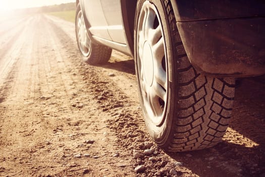 car tire on gravel road in evening light