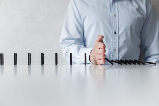 Man prevent of domino falling. Social distancing and saving from spreading virus, concept.