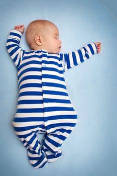 little boy sleeping on soft blue blanket