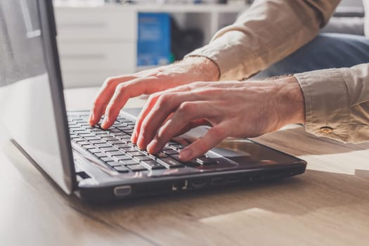 Freelancer young man working on laptop at home during isolation period