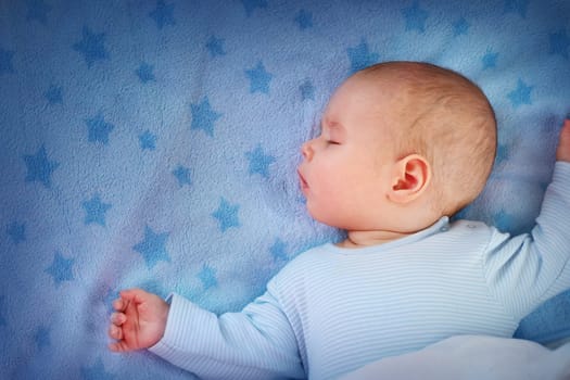 3 month old baby sleeping on blue blanket with stars
