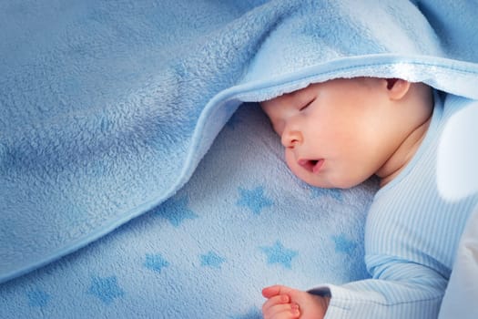 3 month old baby sleeping on blue blanket with stars